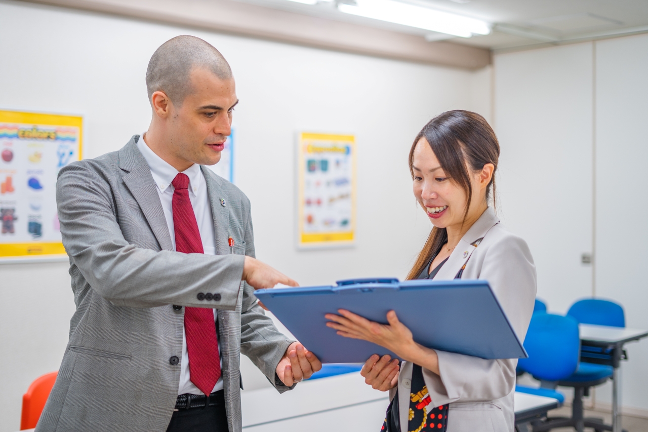 Trainer reviews document with school staff